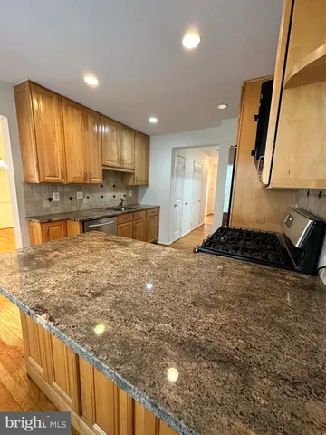 a large kitchen with kitchen island granite countertop a stove a sink and a refrigerator