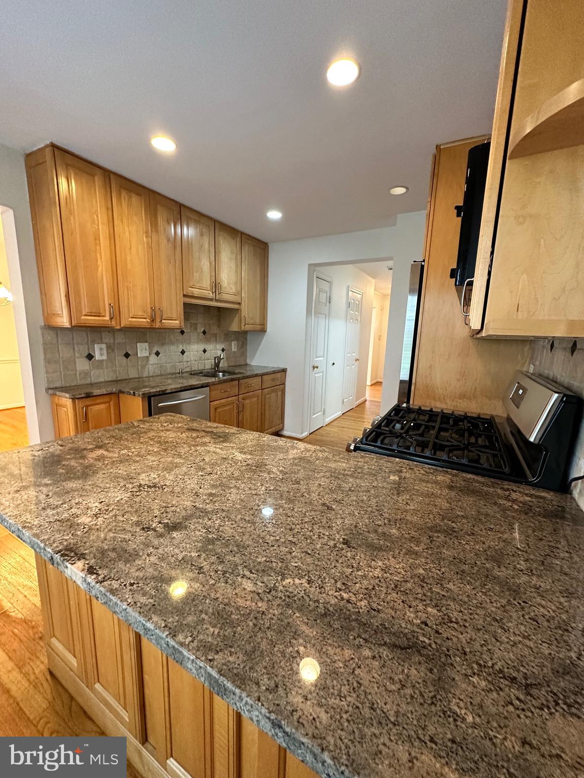 2258 Cartbridge Road Falls Church, VA 22043 - Photo 7 of 35 a large kitchen with kitchen island granite countertop a stove a sink and a refrigerator