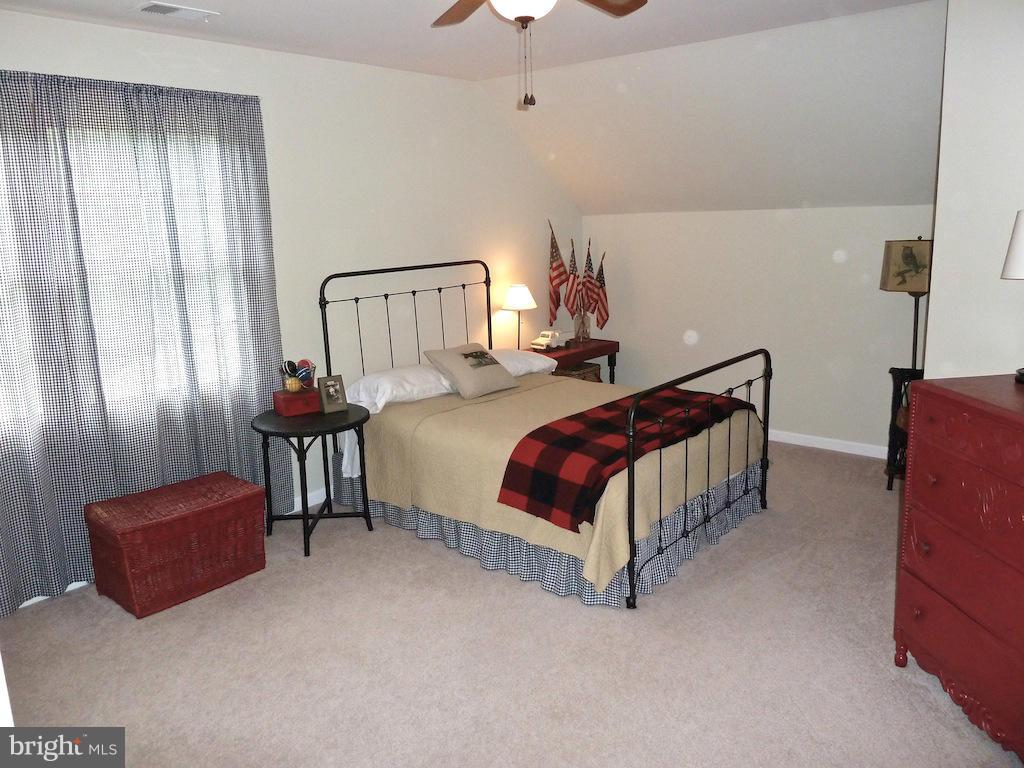 7035 Olinger Road Marshall, VA 20115 - Photo 19 of 25 a spacious bedroom with a bed and a chandelier