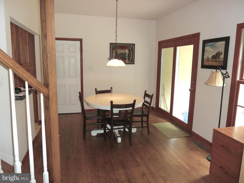 7035 Olinger Road Marshall, VA 20115 - Photo 6 of 25 a dining room with wooden floor a chandelier a wooden table and chairs