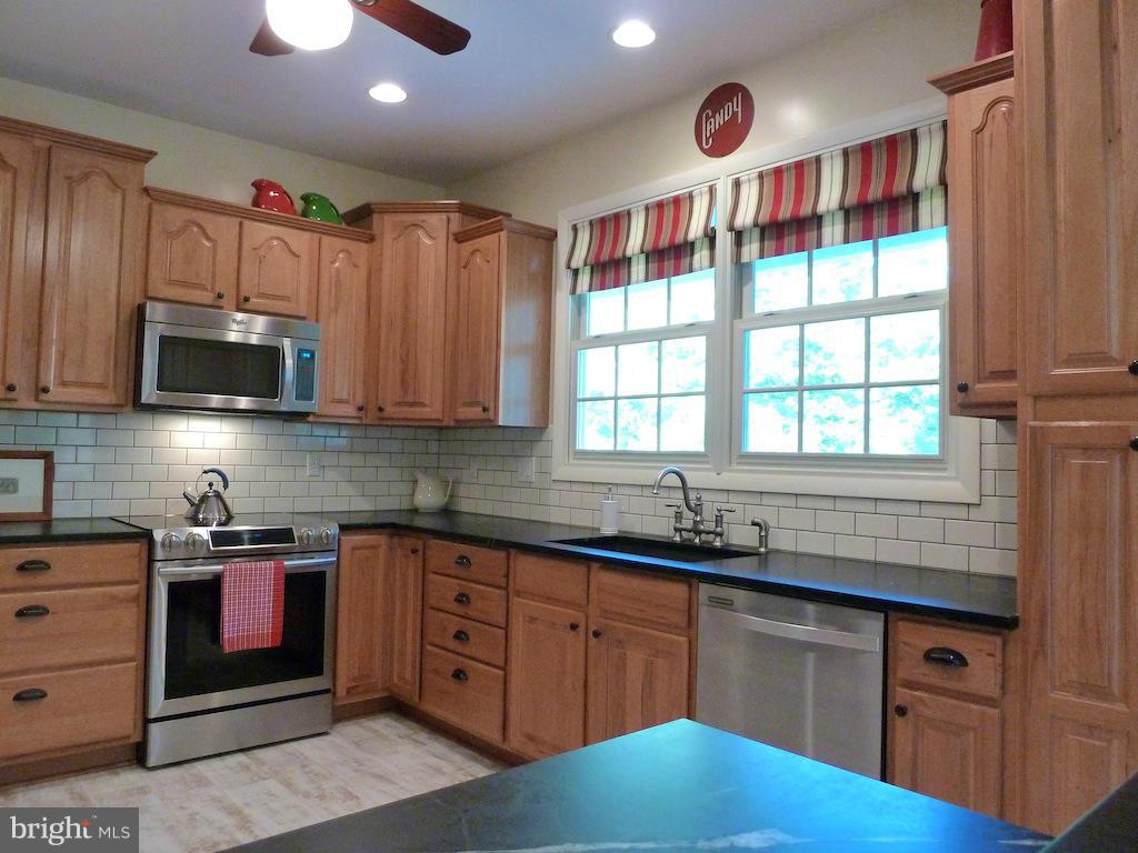7035 Olinger Road Marshall, VA 20115 - Photo 7 of 25 a kitchen with stainless steel appliances granite countertop a sink a stove cabinets and a window