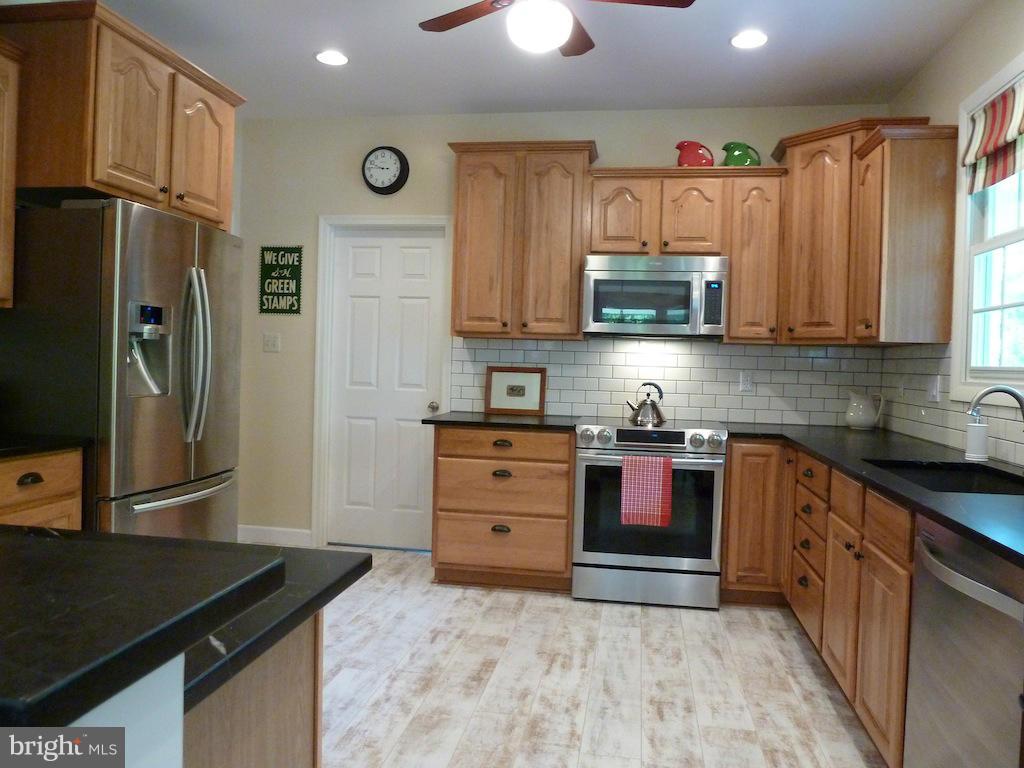 7035 Olinger Road Marshall, VA 20115 - Photo 8 of 25 a kitchen with stainless steel appliances granite countertop a refrigerator and a stove top oven