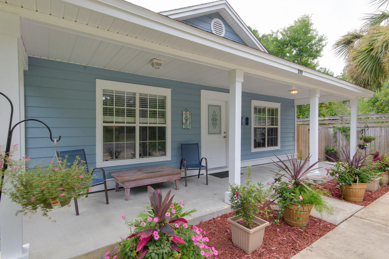 a front view of a house with a potted plant and a bench