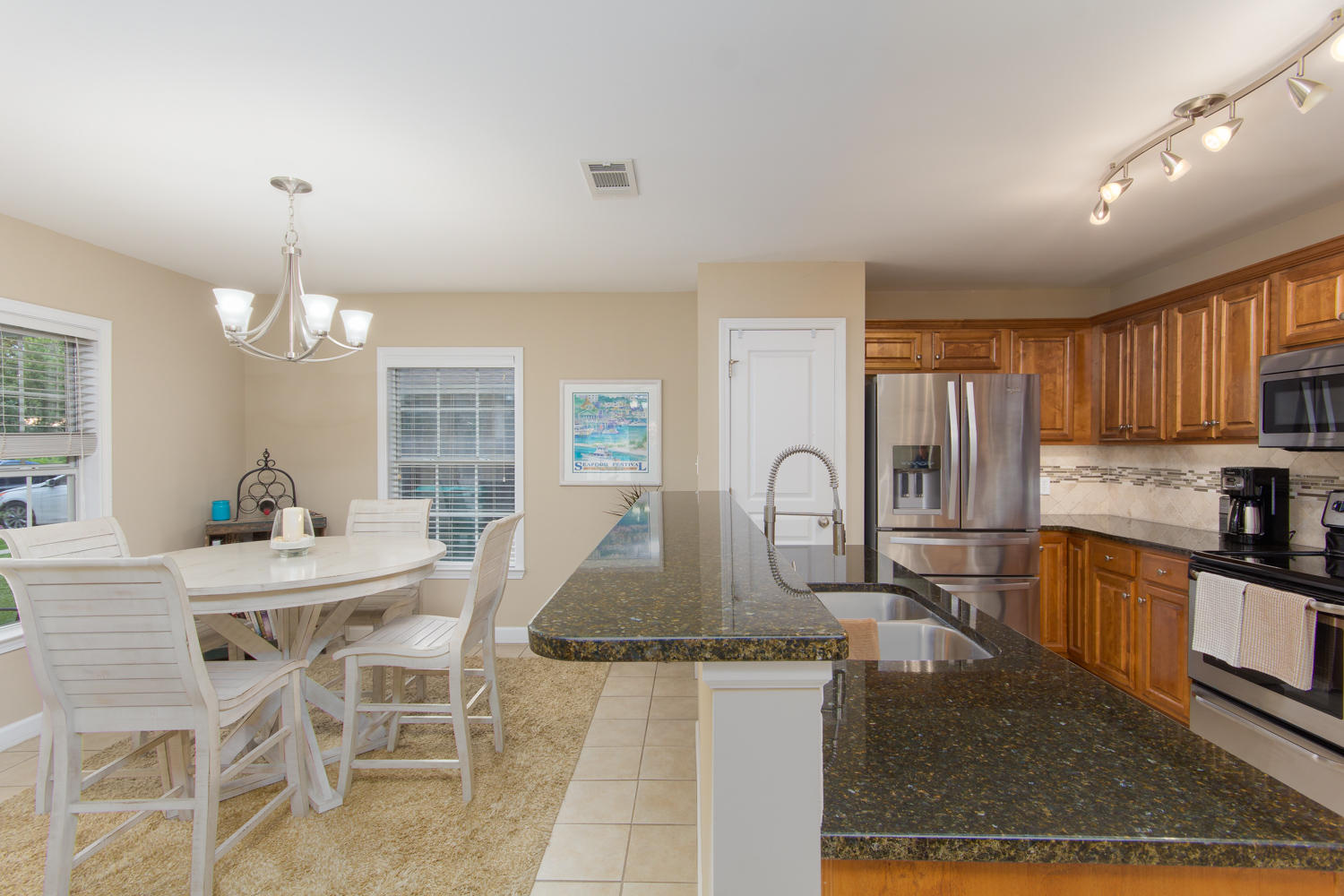 289 South 2nd Street Santa Rosa Beach, FL 32459 - Photo 7 of 22 a kitchen with stainless steel appliances granite countertop a stove top oven a sink dishwasher and white cabinets with wooden floor
