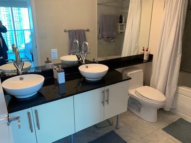 a bathroom with a granite countertop toilet sink and mirror