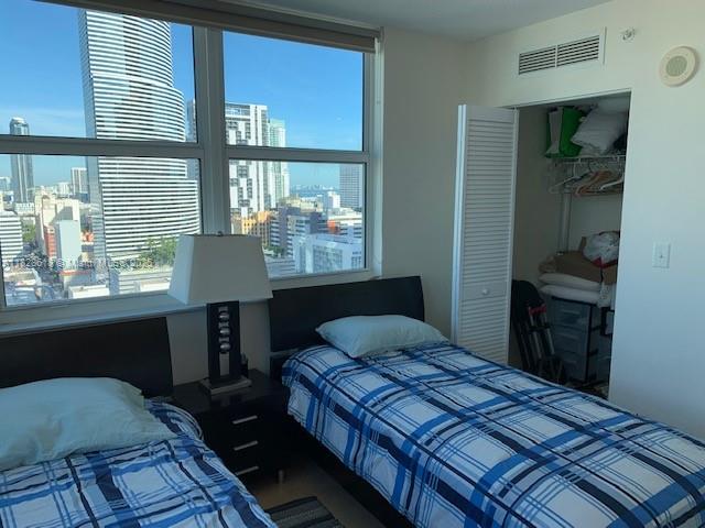 31 Southeast 5th Street, Unit 2601 Miami, FL 33131 - Photo 22 of 41 a bedroom with a bed and wooden floor