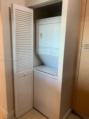 a balcony with table and chairs and potted plants