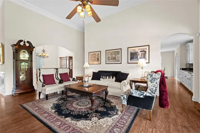 a kitchen with stainless steel appliances granite countertop a sink a stove and chairs with wooden floor
