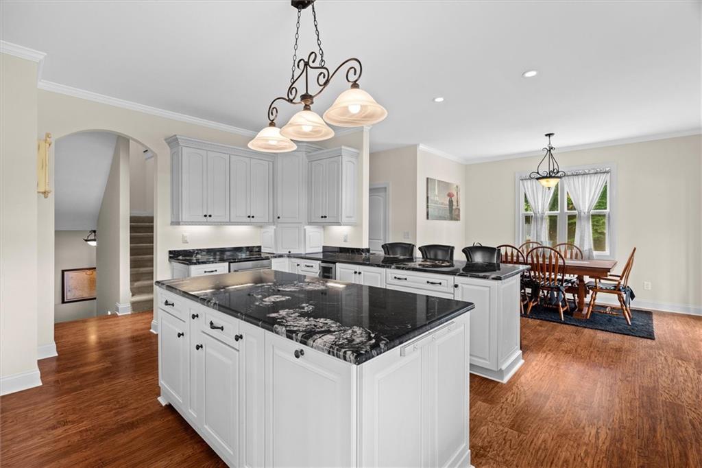 2191 Lakeview Parkway Villa Rica, GA 30180 - Photo 18 of 96 a kitchen with stainless steel appliances granite countertop a sink a stove and chairs with wooden floor