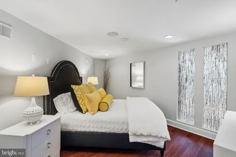 a bedroom with a bed and a lamp on dresser