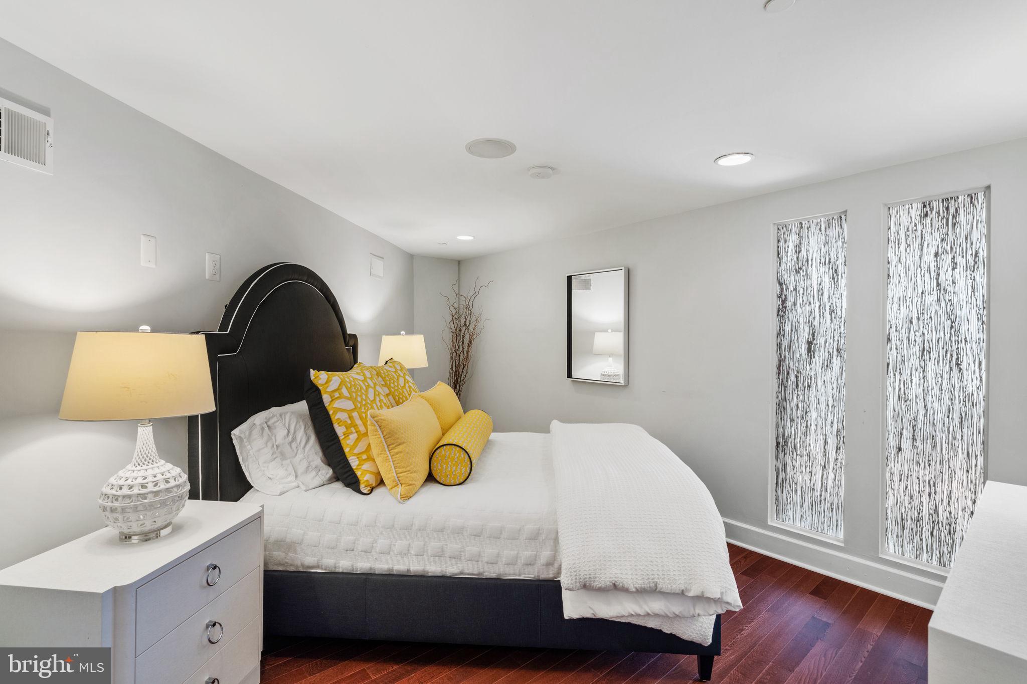 2200-28 Arch Street, Unit 1205 Philadelphia, PA 19103 - Photo 11 of 48 a bedroom with a bed and a lamp on dresser