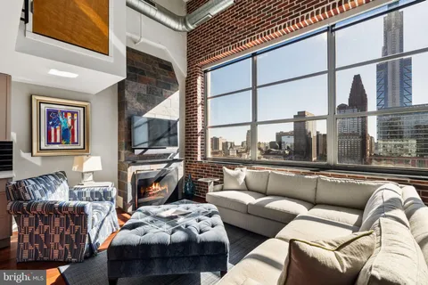 a living room with furniture a flat screen tv and a fireplace