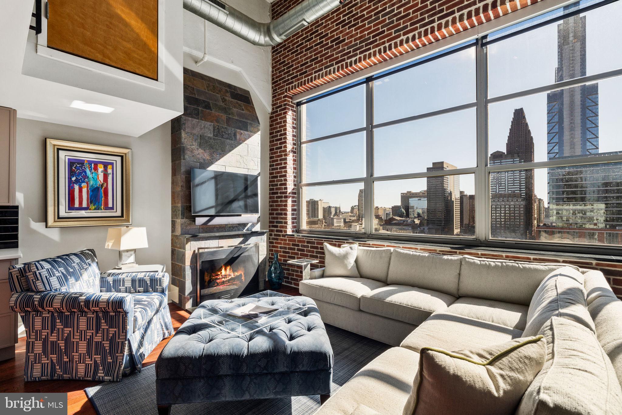 2200-28 Arch Street, Unit 1205 Philadelphia, PA 19103 - Photo 4 of 48 a living room with furniture a flat screen tv and a fireplace