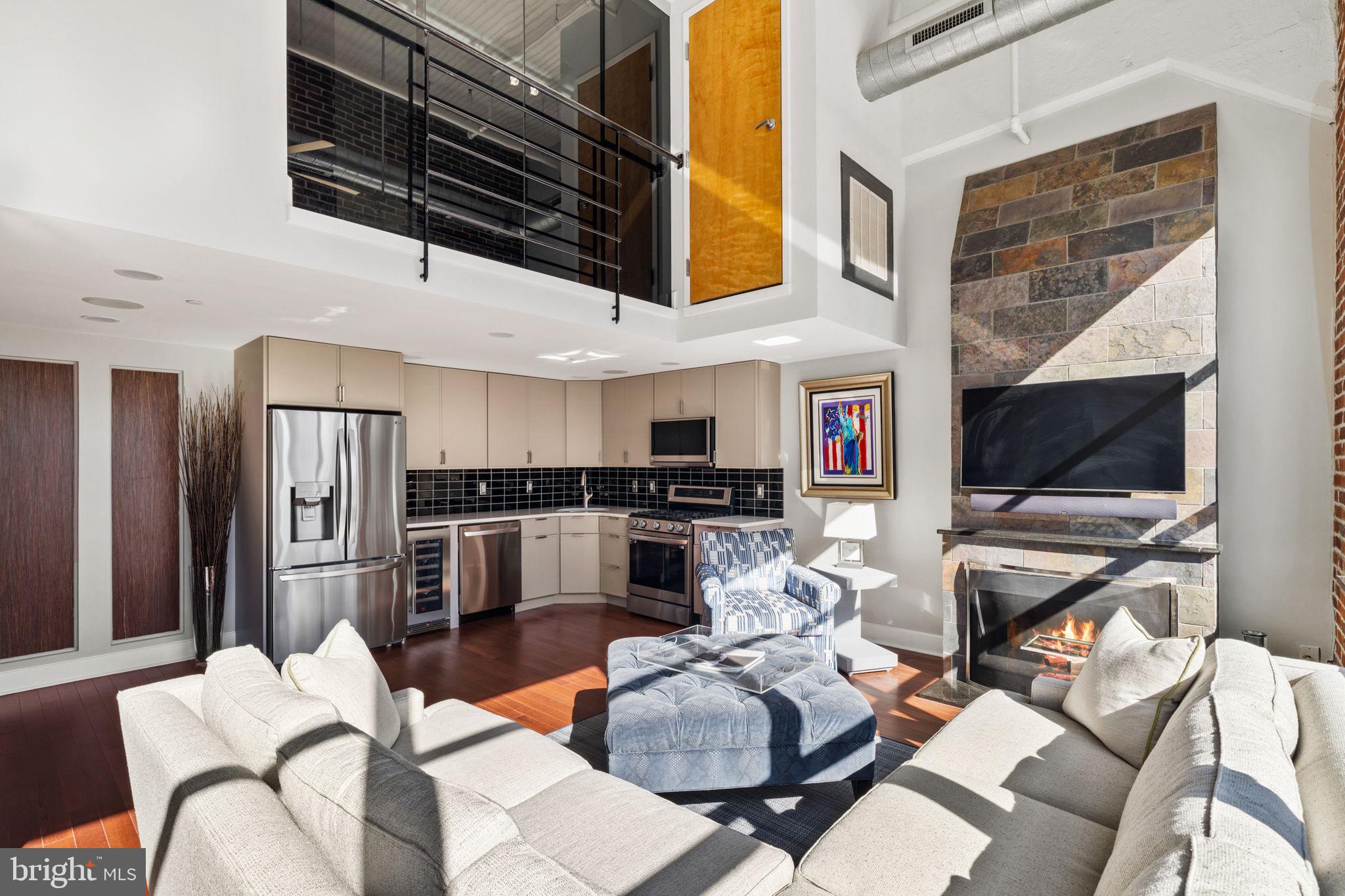 2200-28 Arch Street, Unit 1205 Philadelphia, PA 19103 - Photo 7 of 48 a living room with stainless steel appliances furniture a flat screen tv and a kitchen view