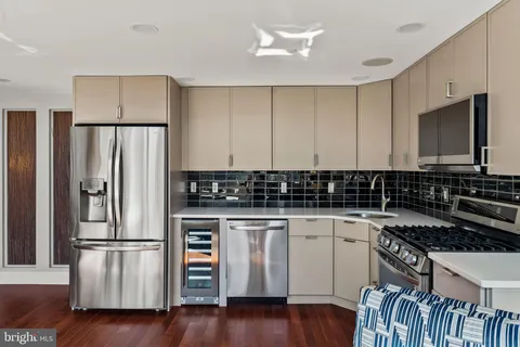a kitchen with wooden floor and stainless steel appliances