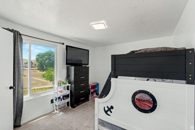 3689 Lasso Loop Circle Magna, UT 84044 - Photo 9 of 26 2nd room upstairs with carpeted flooring, a rectangular window with white framing, and a ceiling-mounted flush light fixture