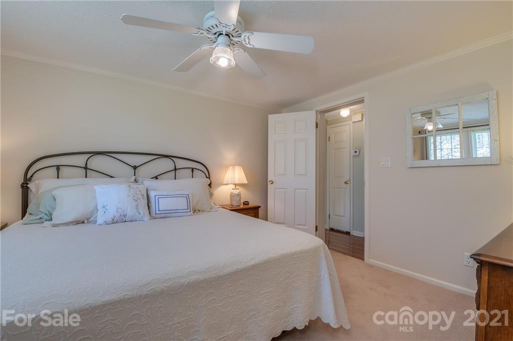 569 Flynn Road Rutherfordton, NC 28139 - Photo 29 of 34 a bedroom with a large bed and a chandelier