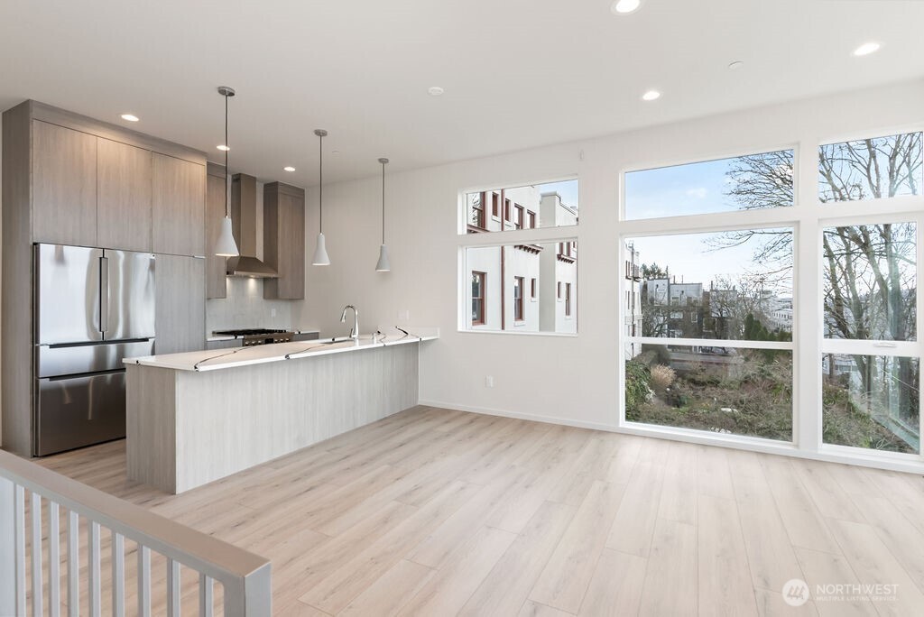 2921 Franklin Avenue East, Unit B Seattle, WA 98102 - Photo 5 of 30 a large kitchen with kitchen island a large window a sink and stainless steel appliances