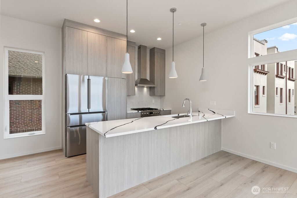 2921 Franklin Avenue East, Unit B Seattle, WA 98102 - Photo 8 of 30 a kitchen with stainless steel appliances granite countertop a sink a stove and a refrigerator