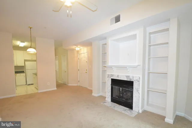 a view of a livingroom with a fireplace cabinet and windows