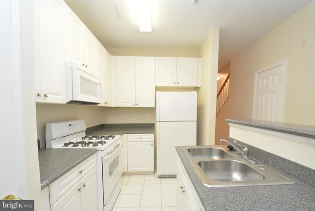 a kitchen with a sink a stove and a refrigerator