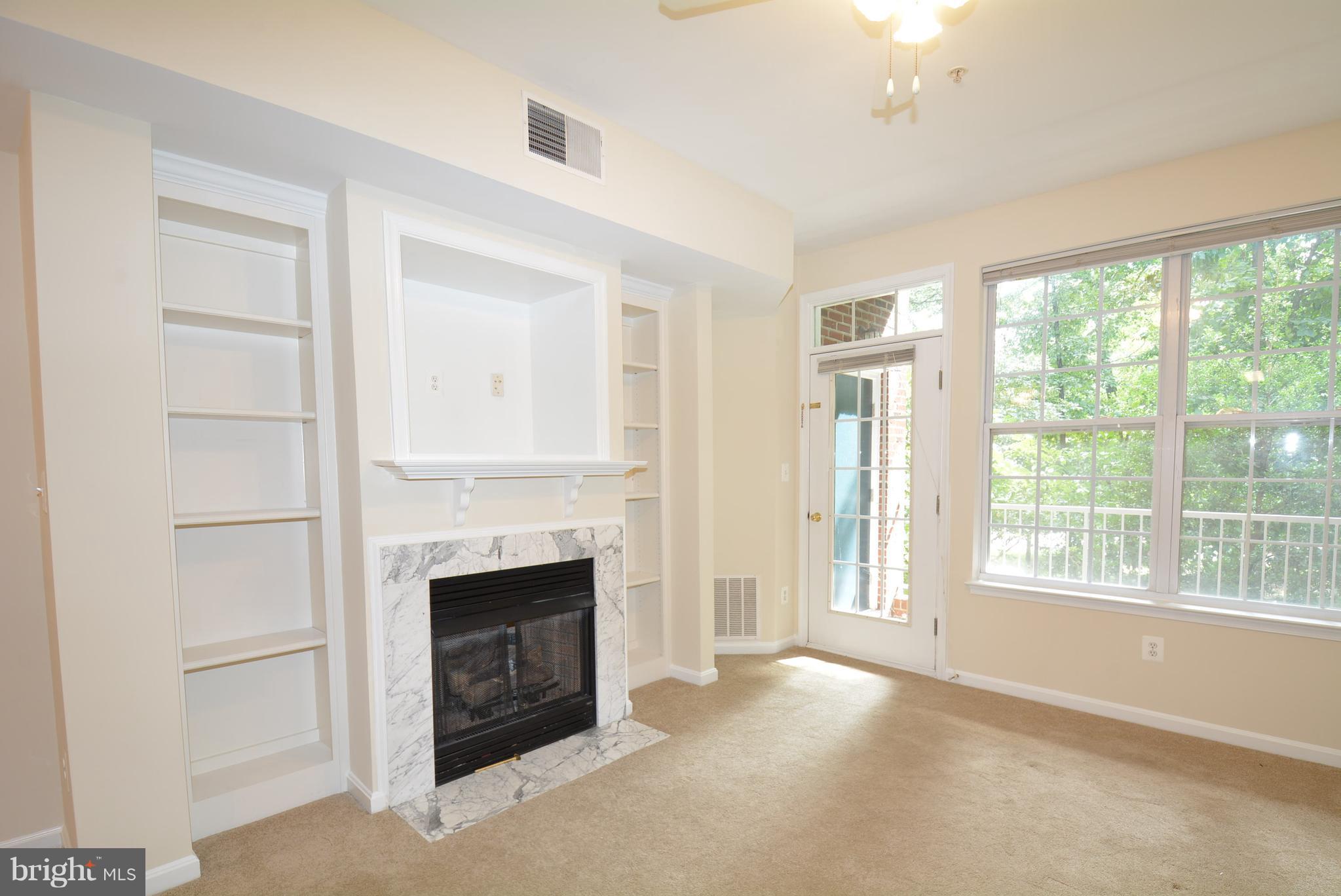 2665 Manhattan Place, Unit 101 Vienna, VA 22180 - Photo 10 of 23 a view of an empty room with a fireplace and a window