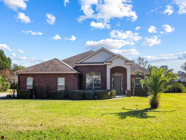 a dining room with furniture a potted plant and wooden floor