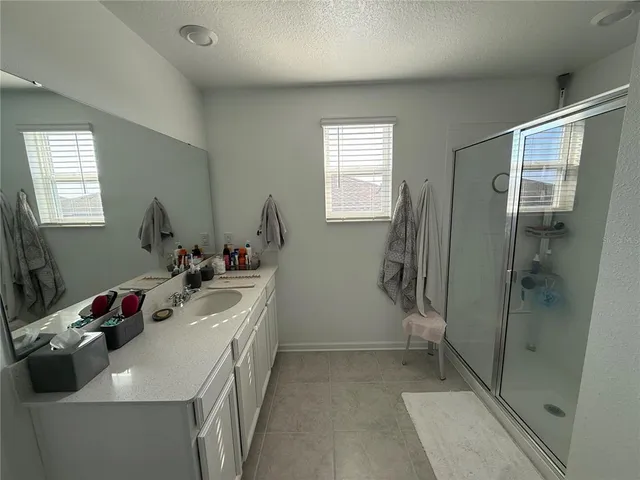 a bathroom with a sink mirror and shower