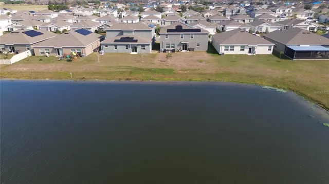 an aerial view of residential houses with outdoor space and trees