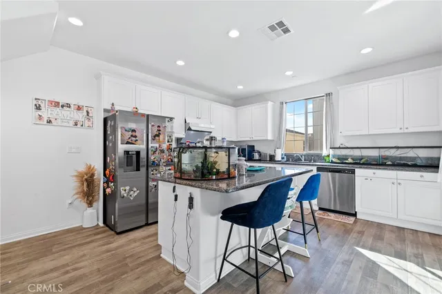 a kitchen with stainless steel appliances granite countertop a refrigerator and a stove top oven