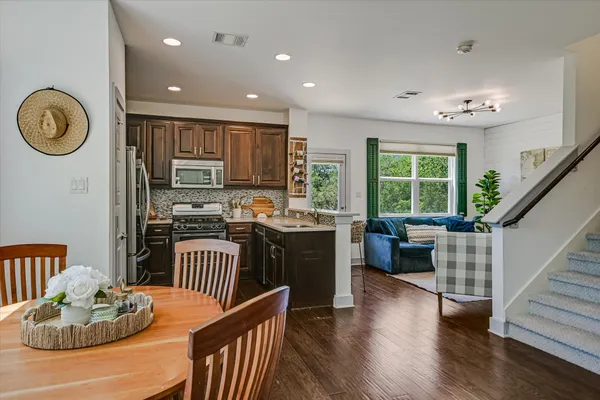 a kitchen with a table chairs a stove and a refrigerator