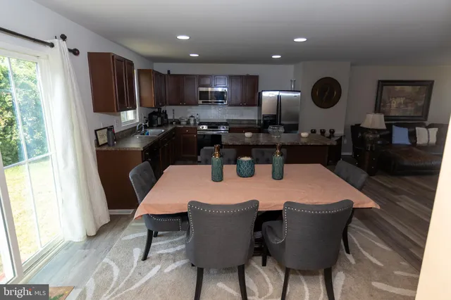 a kitchen with a dining table chairs and refrigerator