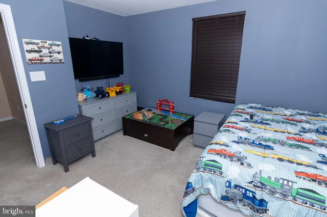 a bed room with a dresser and a flat screen tv