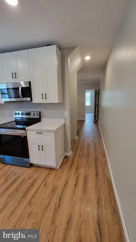 a large kitchen with stainless steel appliances granite countertop a stove a sink and a refrigerator