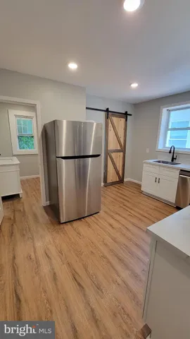 a view of kitchen with stainless steel appliances granite countertop cabinets and wooden floor