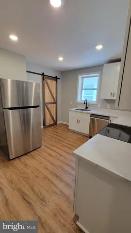 a kitchen with a refrigerator sink and cabinets