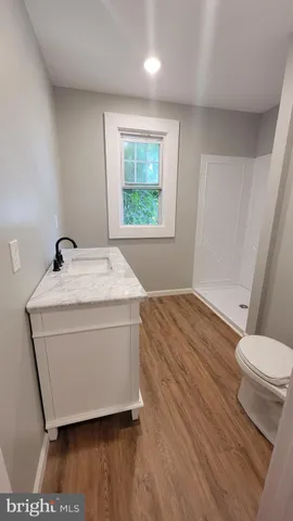 a bathroom with a granite countertop toilet sink and mirror