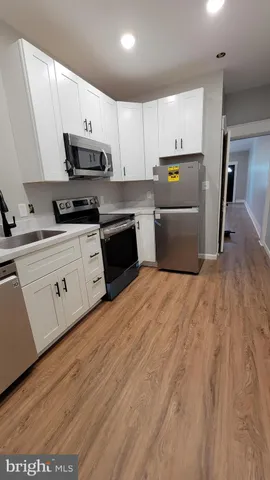 a kitchen with stainless steel appliances granite countertop a refrigerator a stove top oven a sink and dishwasher