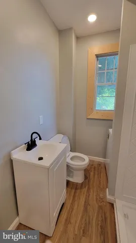a bathroom with a sink a toilet and a window