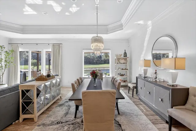 a living room with couches and a dining table with wooden floor