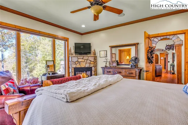 a bedroom with a bed a flat screen tv and a large window