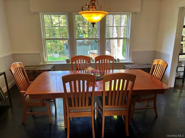 a view of a dining room with furniture a chandelier and wooden floor