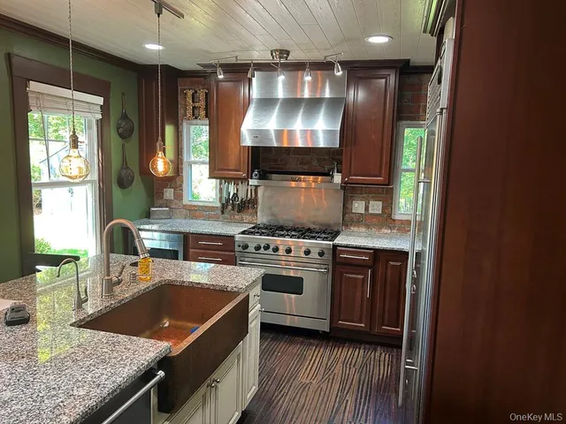 a kitchen with stainless steel appliances granite countertop a sink stove and refrigerator