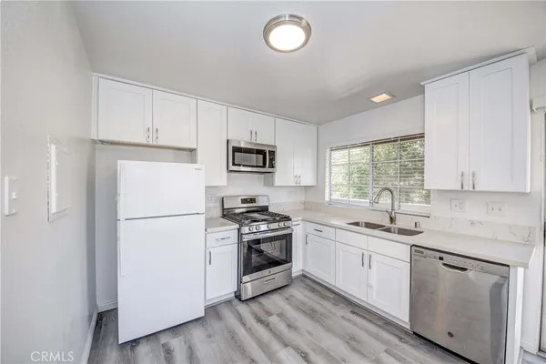 a kitchen with white cabinets and white appliances