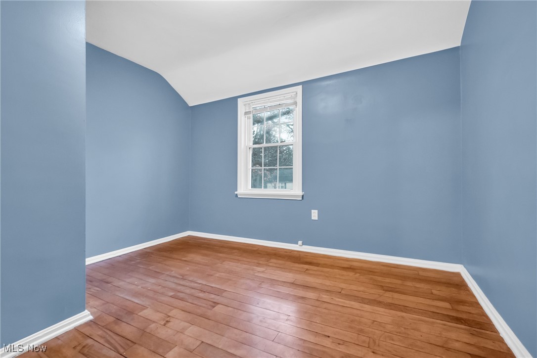 1605 Laclede Road Cleveland, OH 44121 - Photo 34 of 40 Unfurnished room with lofted ceiling, hardwood / wood-style floors, and baseboards