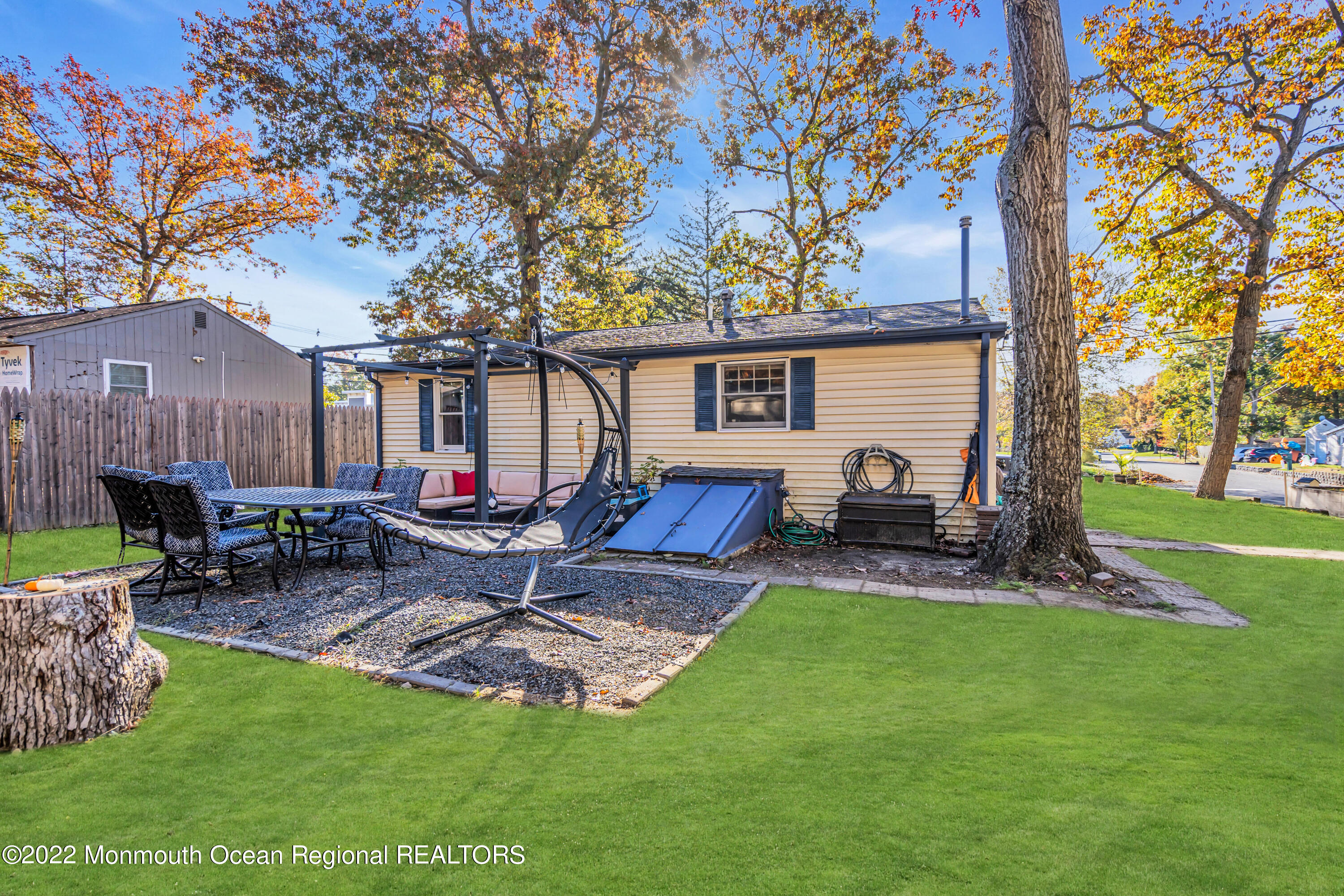 415 Shady Lane Howell, NJ 07731 - Photo 17 of 20 a view of a backyard with table and chairs potted plants and a big yard with wooden fence