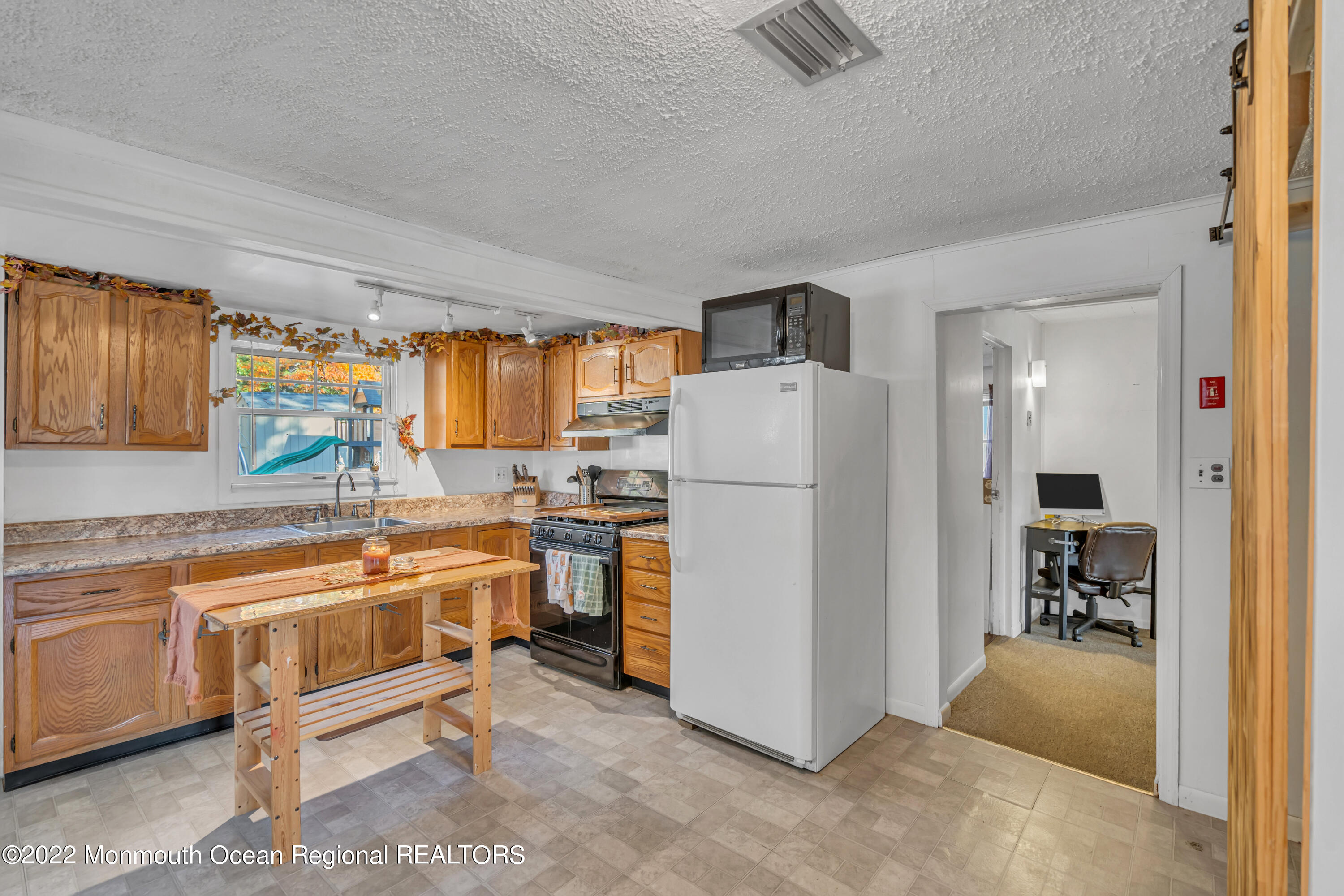 415 Shady Lane Howell, NJ 07731 - Photo 6 of 20 a room with kitchen island a large window and a refrigerator