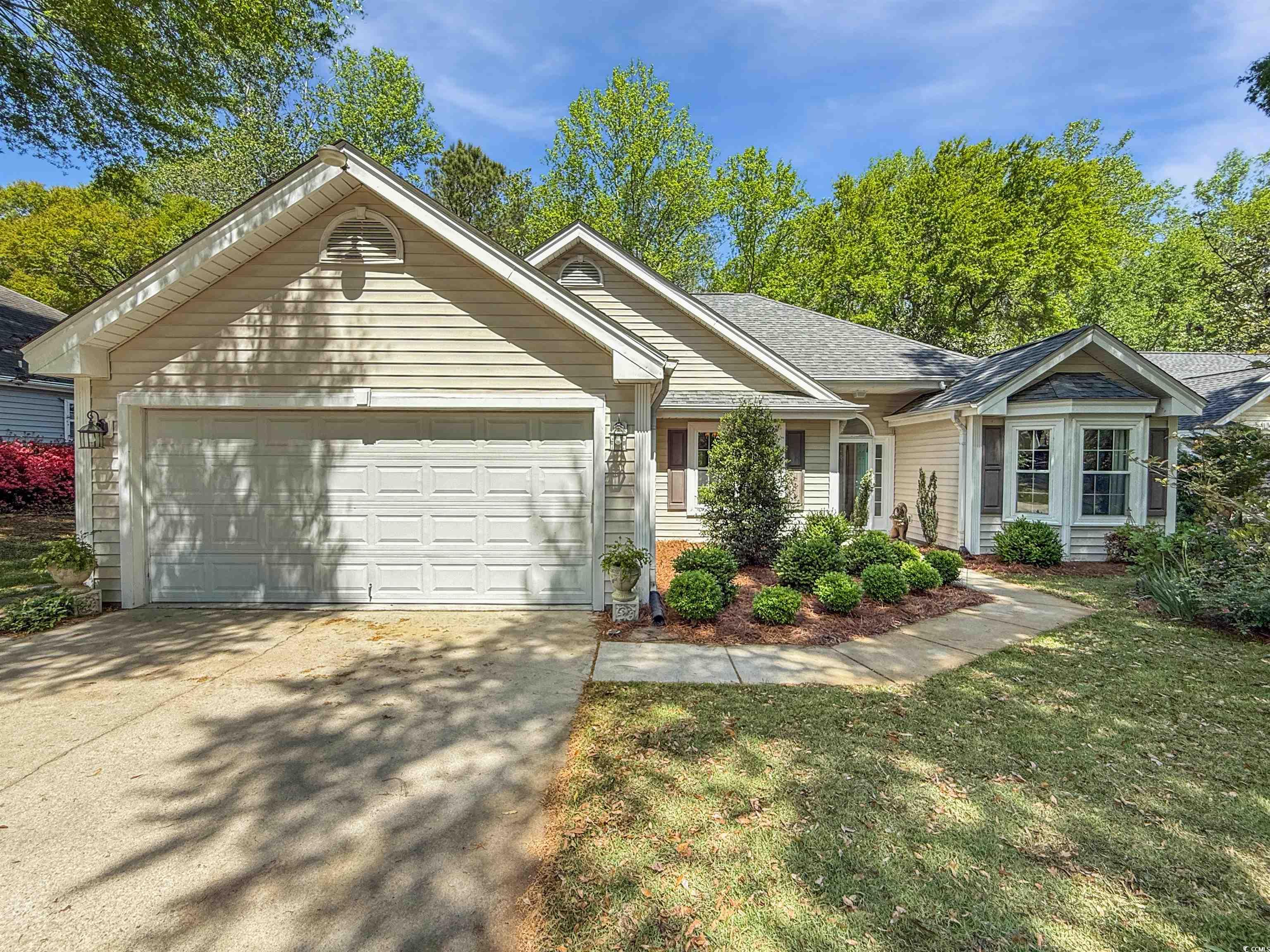 Ranch-style house with a shingled roof, a garage,