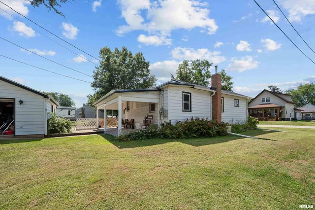 a view of a house with a big yard and potted plants
