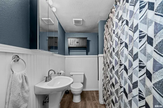 a bathroom with a sink and mirror with toilet